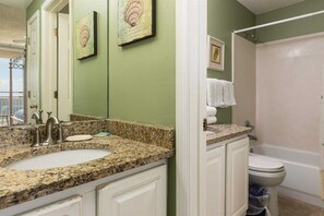 A bathroom with a granite countertop sink, a white toilet, and a shower area. - Number One Rated Resort Along Entire Coast! 5 Star Rated Unit (Gulf Shores)