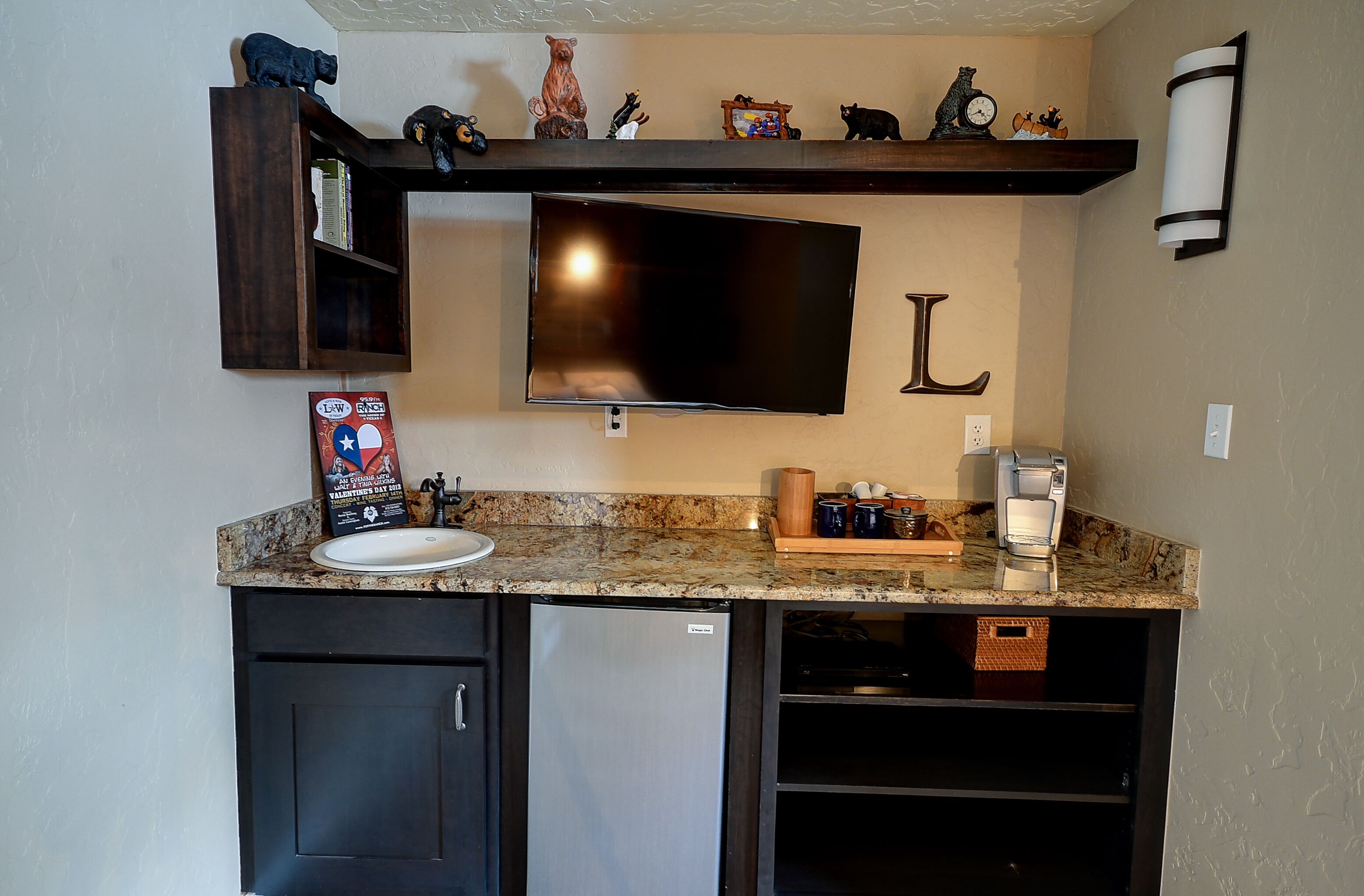 A kitchen with a built-in refrigerator, a sink, and a countertop with a coffee maker and a basket.
