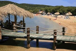 Enjoy a serene beachside retreat with access to the shore via a wooden pier.