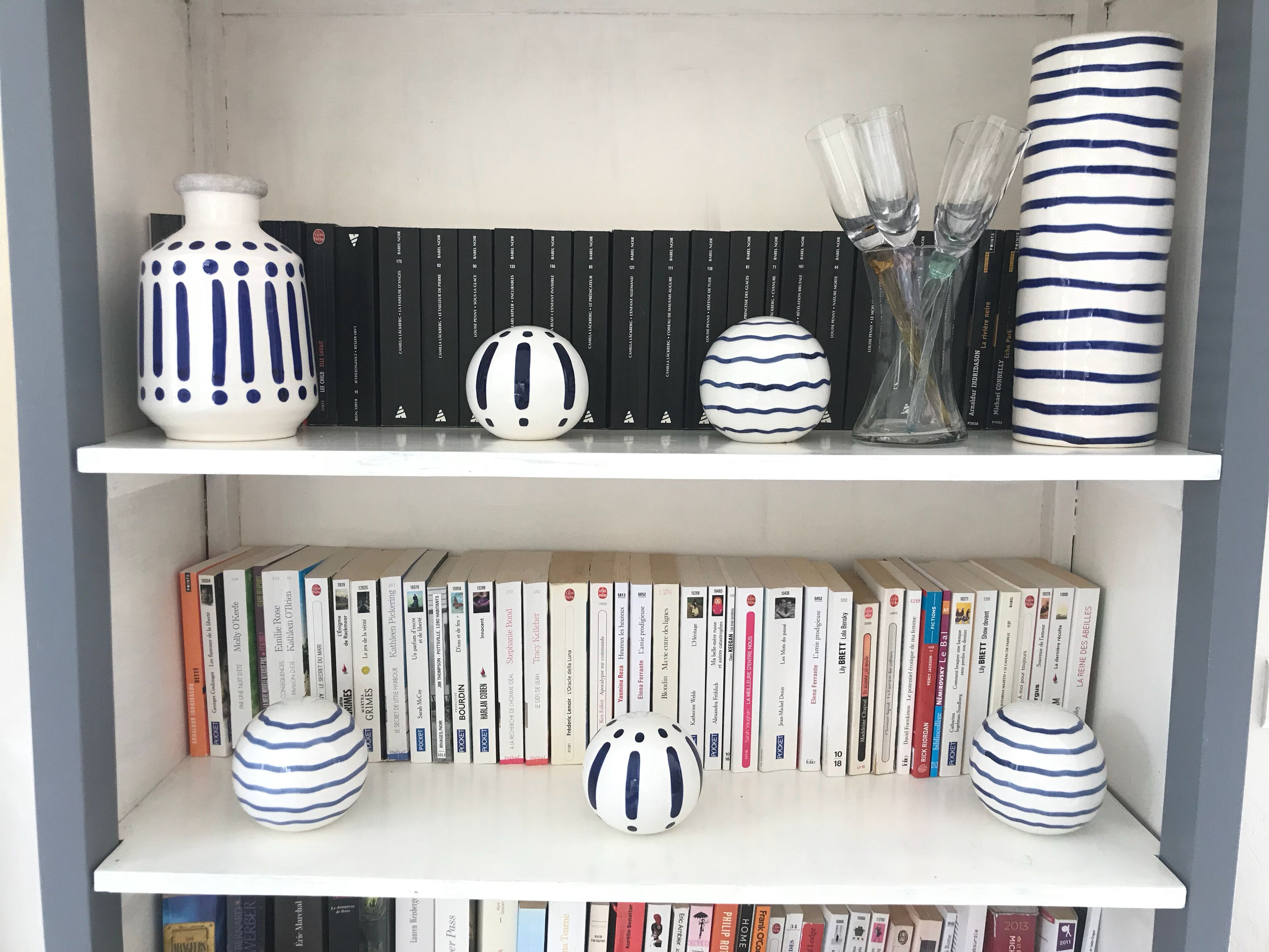 A bookshelf with books and decorative vases.