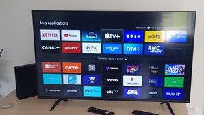 Ein Flachbildfernseher auf einem Standfuß, auf dem eine Auswahl an Streaming-Apps angezeigt wird.