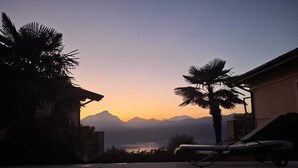 Une piscine avec vue sur les montagnes au coucher du soleil.