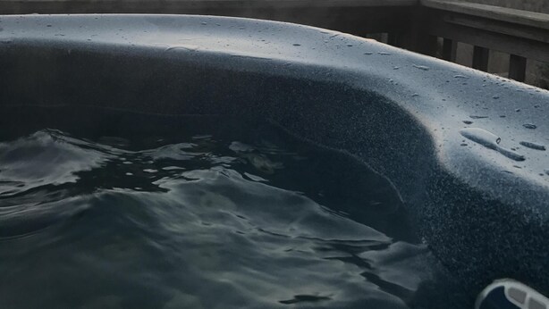 A hot tub with water, surrounded by a mountainous landscape during sunset. - Close proximity to Hawksnest, Otter Falls -- and all the High Country offers! (Seven Devils)