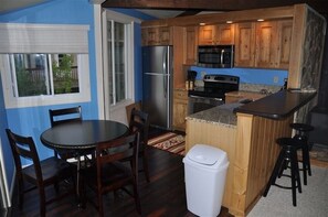 Kitchen area with dining table and modern appliances.