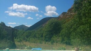A swimming pool with clear blue water, surrounded by lush greenery and mountains in the background. - Into the wild: Charming house, surrounded by nature, large private pool. (Romeyer)