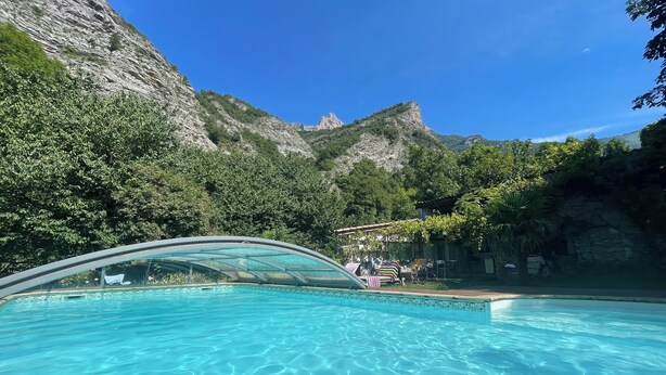 A swimming pool with clear water, surrounded by greenery and a mountainous backdrop. - Into the wild: Charming house, surrounded by nature, large private pool. (Romeyer)