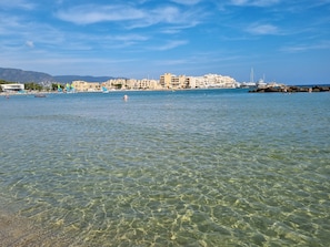 A coastal town with clear waters, buildings, and boats.