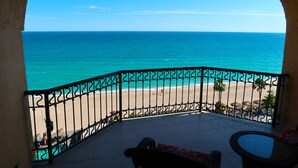 A balcony with a view of the ocean and beach.