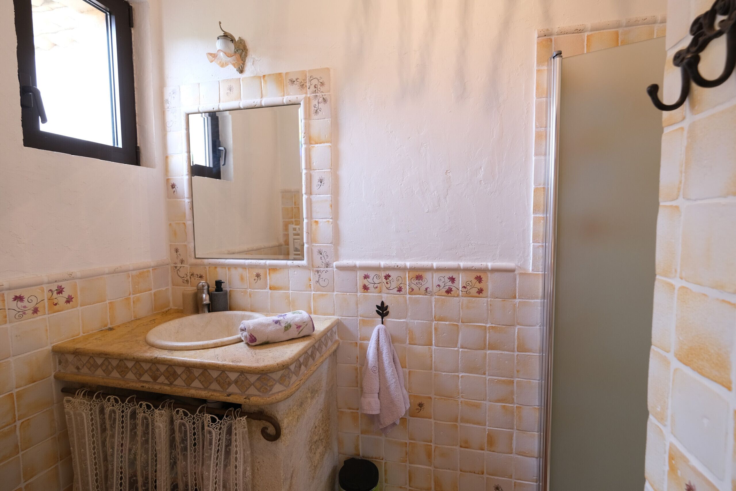 A bathroom with a sink, mirror, and shower.