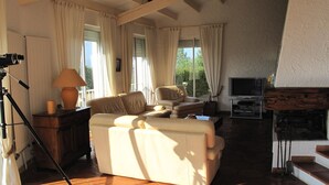 Een woonkamer met een bank, een televisie en een open haard.