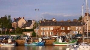Un port de plaisance où sont amarrés plusieurs bateaux, entouré d’immeubles d’habitation.