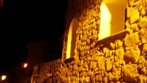 Un edificio de piedra con ventanas arqueadas y un interior iluminado.
