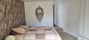 Un dormitorio con una cama, un adorno en la pared y un panel de madera.