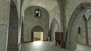 Um corredor com tetos abobadados e paredes de pedra.
