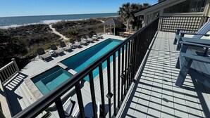 Une piscine avec vue sur l’océan, une terrasse avec des chaises longues et un belvédère.