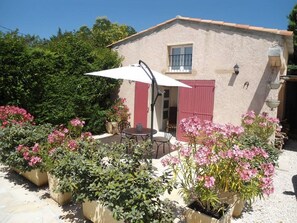 A house with a patio, outdoor seating, and potted plants.