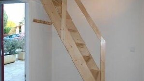 A wooden staircase in a room with white walls and tiled flooring. - LOCATION DUPLEX 4 PERS. 45M2 NEAR SAINTE MAXIME VAR ..IDEALEMENT LOCATED ... (Le Muy)