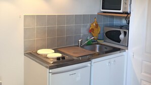 A compact kitchen with a built-in microwave, a sink, and a small refrigerator. - LOCATION DUPLEX 4 PERS. 45M2 NEAR SAINTE MAXIME VAR ..IDEALEMENT LOCATED ... (Le Muy)
