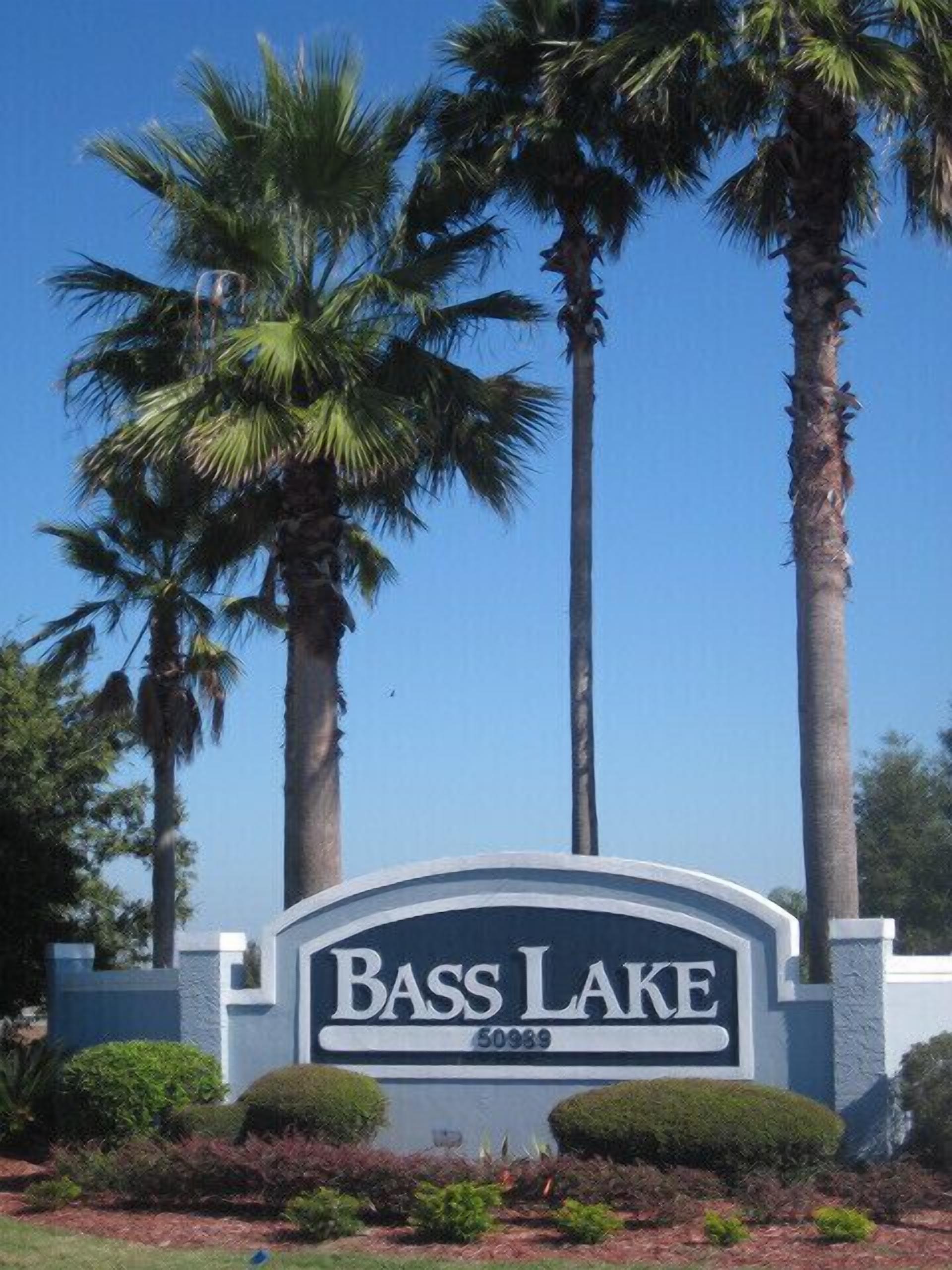 Schild für den Bass Lake, im Hintergrund klarer Himmel und Palmen.