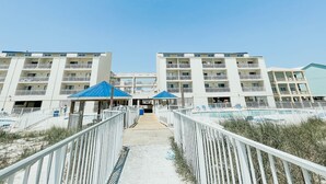 Un hôtel situé en bord de mer, doté de nombreux balcons, d’un espace piscine et d’une promenade couverte.