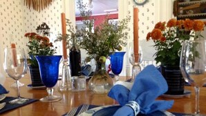 A table set with blue napkins, a plate, cutlery, and blue vases with flowers. - CHARMING, 4-Br, 2-Ba, Full Kitchen Wi-Fi, Mt View, private deck, discounts avail (Franconia)
