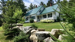A two-story house with a green roof, surrounded by large rocks and greenery. - CHARMING, 4-Br, 2-Ba, Full Kitchen Wi-Fi, Mt View, private deck, discounts avail (Franconia)