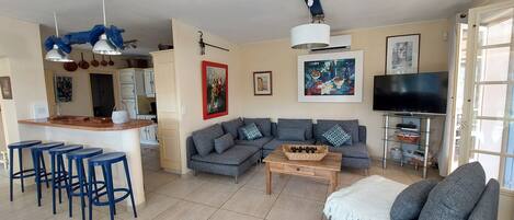 A living room with a sofa, a coffee table, and a TV stand.