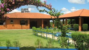 A building with a sign that reads "SEJAM BE EM VINDOS" and a pool area with blue benches. - CHACARA HORTOLAN, BEAUTIFUL AND COZY FOR SPECIAL MOMENTS (ITU)