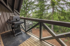 A wooden deck with a grill and a view of a forest. - Pinnacle Ridge 37 - Ski in Ski out, Private Hot Tub, Wood Fireplace (Whistler)
