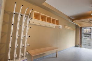 A hallway with a wooden bench, a coat rack, and a wooden shelf with hooks. - Pinnacle Ridge, 3 Bedroom + Den (Whistler)