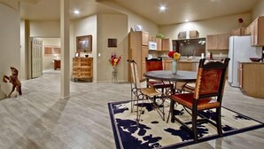 A spacious kitchen with wooden cabinets, a dining table with chairs, and a refrigerator. - Large Balcony, Exceptional Views. (Tucson)