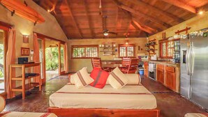 A spacious room with a large bed, a dining table, and a kitchen area. - Casa Sueños: Stunning Bay-view Retreat • Infinity Pool • Walk to Town • Sleeps 9 (San Juan Del Sur)