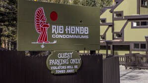 A sign for Rio Hondo Condominiums indicating guest parking only with a warning that violators will be towed.