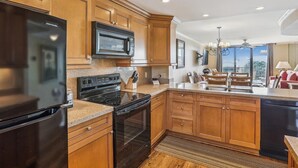 A modern kitchen with wooden cabinets, a black refrigerator, a microwave, a stove, and a dishwasher. - Top Floor Condo. Beautiful Ocean Views. Great Mid-Island Location (Hilton Head Island)