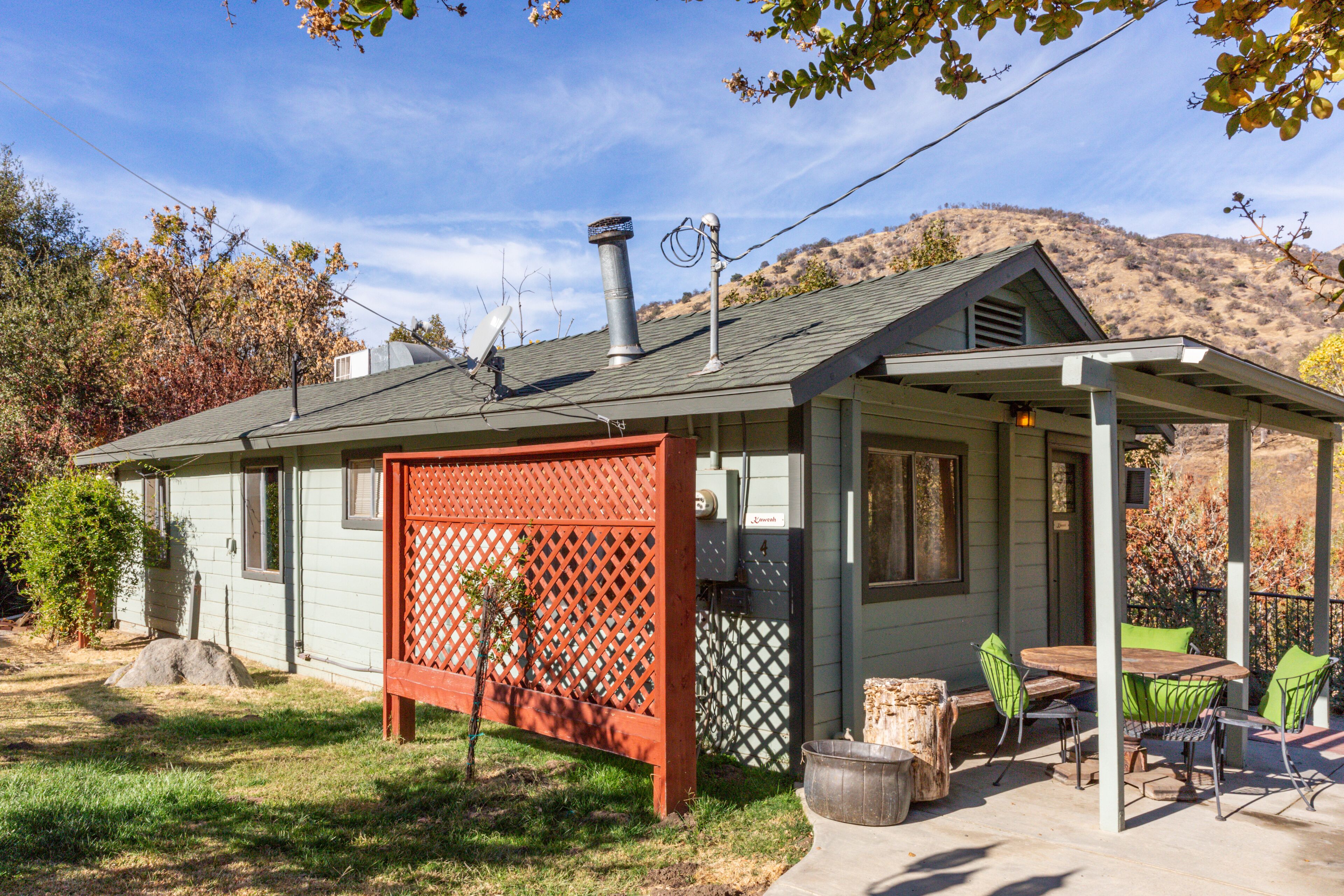 A house with a covered patio, a chimney, and a fenced yard.