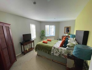 A bedroom with a bed, a television, a desk, and a wardrobe. - Windrush Turret Lodge & Hot Tub - Relax by the Lake Surrounded by Nature (South Cerney)