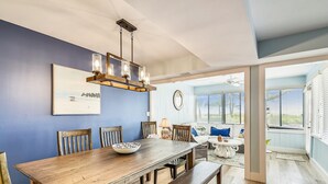 Un comedor con una mesa de madera, sillas y una araña.