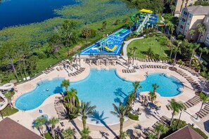 A resort with a large pool, a water park, and a beach area.