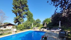 Ein Schwimmbecken mit Liegestühlen und einer Steinterrasse.