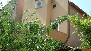 A building with a beige facade, a small window, and a visible door. - Apartment on the beach in Baia dei Turchi- 6/7 persons (Brucoli)
