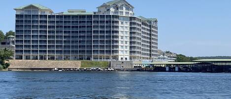 A multi-story hotel with a waterfront view, featuring balconies and a covered walkway.