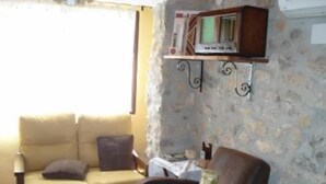 Uma sala de estar acolhedora com um sofá, uma mesa com uma vela e uma estante decorativa.