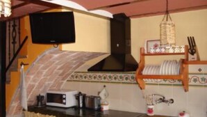 Uma cozinha equipada com micro-ondas, torradeira, pia e luminária pendente.