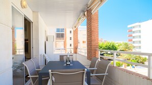 Ein Balkon mit Tisch für zwei Personen, einer Flasche und Gläsern.