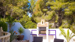 An outdoor patio area with wicker furniture, a barbecue grill, and potted plants. - Lovely modern 2 bed apartment sleeps 4 FREE WiFi A/C, TV, private Pool & parking (Teulada)