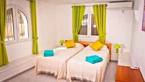 A room with two beds, green curtains, a window, and a wooden nightstand. - Lovely modern 2 bed apartment sleeps 4 FREE WiFi A/C, TV, private Pool & parking (Teulada)