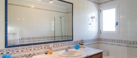 A bathroom with two sinks, a large mirror, and a bathtub.