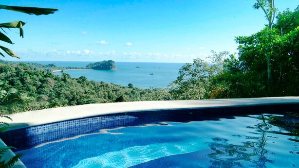A swimming pool with a view of the ocean and a tropical landscape. - Balinese Style Tropical Villa w/4 suites Huge Ocean Views Private Pool  (Manuel Antonio)