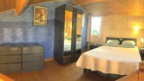 A bedroom with a bed, dresser, wardrobe, and a window with curtains. - Gîtes La Glycine facing the Saint-Emilion river (Vignonet)