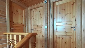 A wooden interior with a polished floor, a wooden staircase, and two doors with a simple design. - Chalet - La Tzoumaz Verbier - on the slopes (La Tzoumaz)